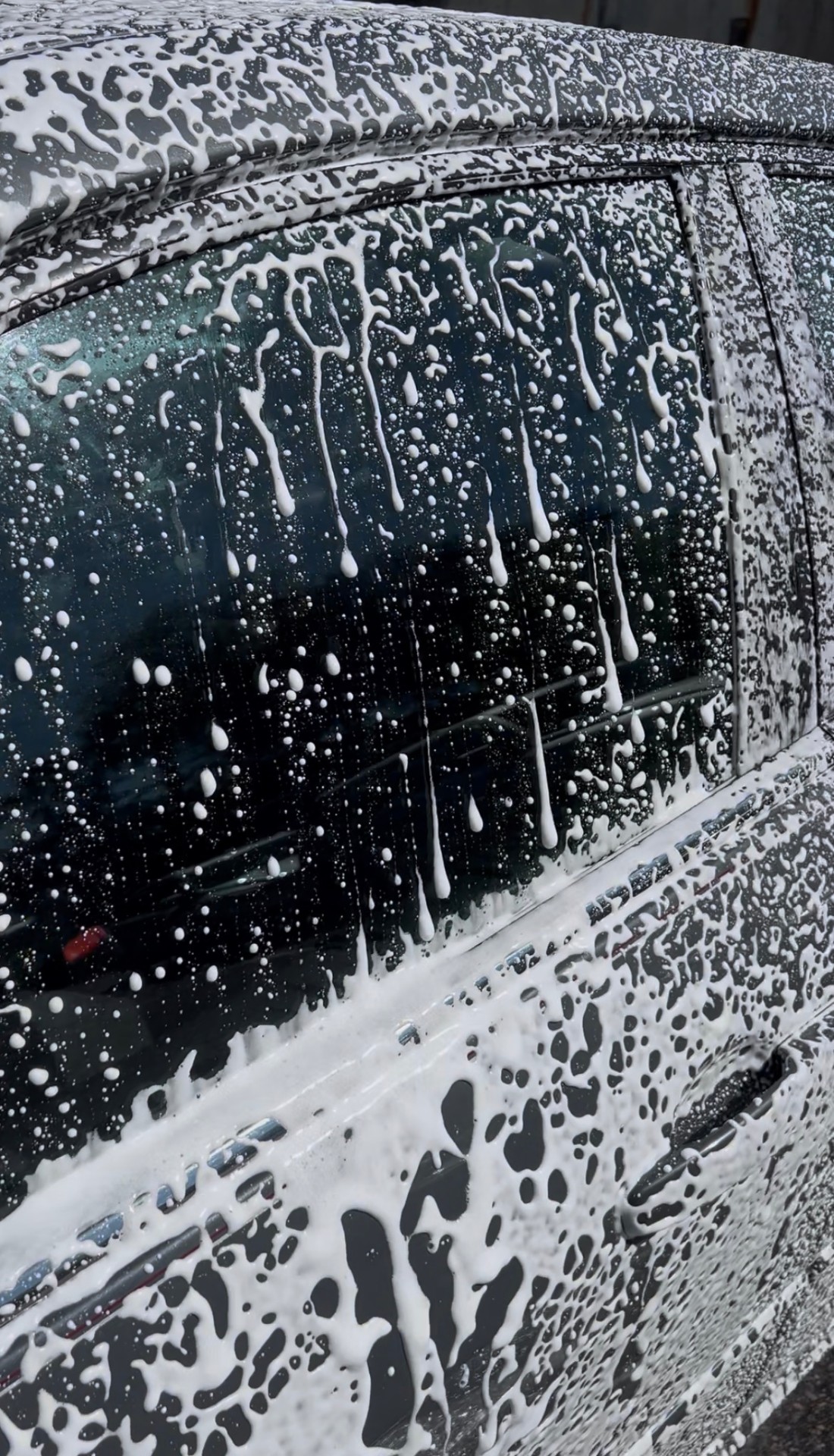 Glossy black car with water beading after professional detail